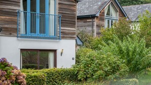A wooden house with a balcony and a window. - Pet Friendly Luxury 5* 2 Bedroom Cottage with Hot Tub - Haven (Truro)
