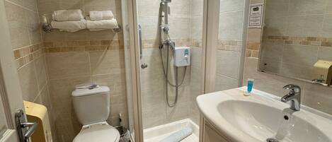 A modern bathroom with a glass-enclosed shower, a white sink, and a toilet.