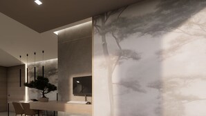 A modern interior with a minimalist design, featuring a dining area with a table and chairs, a large wall-mounted TV, and a large window with a tree view. - Bellettinihome (Cervia)