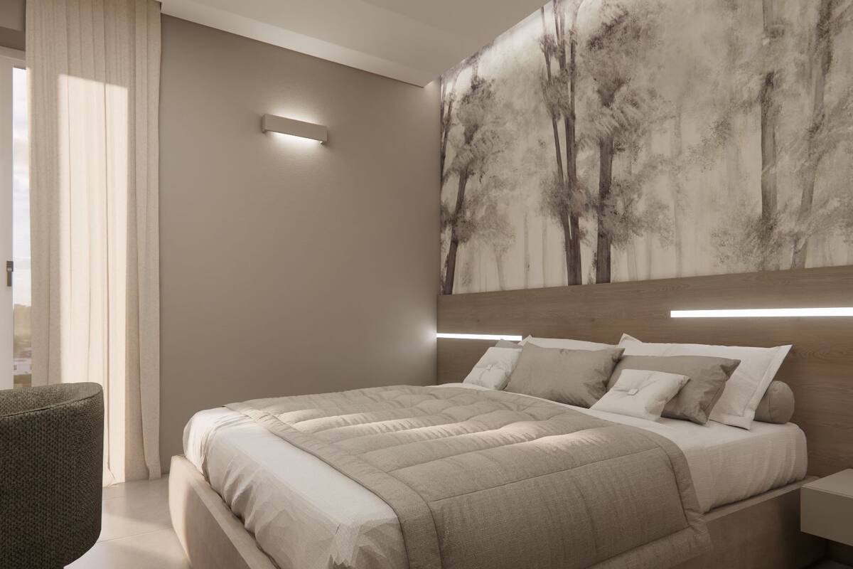 Ein modernes Schlafzimmer mit einem großen Bett, einem Nachttisch, einer Wandleuchte und einem großen Gemälde.