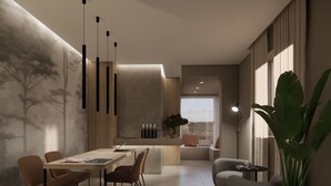 A modern living room with a dining area, a large plant, and a view of the city. - Bellettinihome (Cervia)