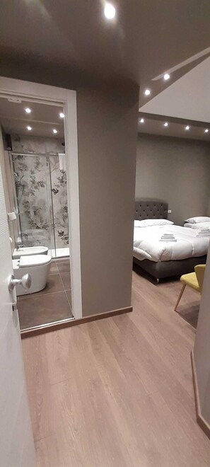 Relax in a spacious room with a large bed, separate bathroom, and additional seating.