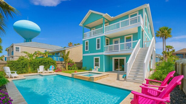 A two-story house with a swimming pool, a water tower, and a staircase leading to the upper floor. - Upscale & Spacious Home - Renovated - Pool (South Padre Island)