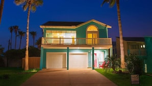 A two-story house with a balcony, garage, and a well-lit front entrance. - Upscale & Spacious Home - Renovated - Pool (South Padre Island)
