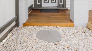 A house entrance with a wooden porch, a double door with a decorative glass panel, and a gravel driveway. - Navi Home, stay like locals (Yarraville)