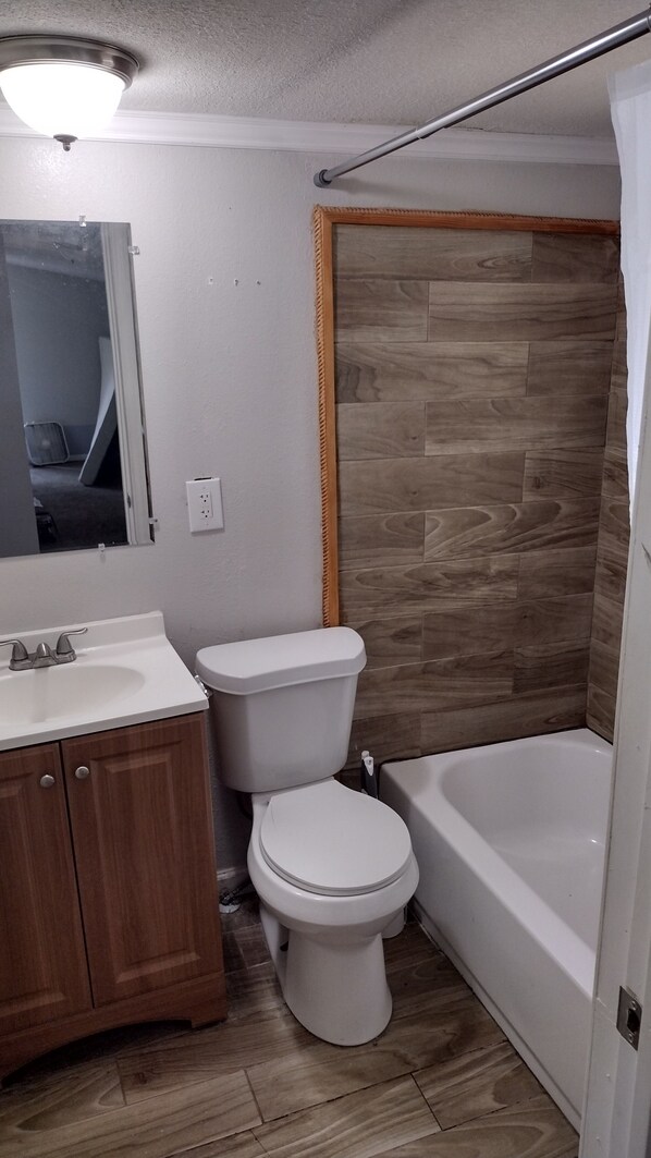 Une salle de bain avec des toilettes, un lavabo et une baignoire.