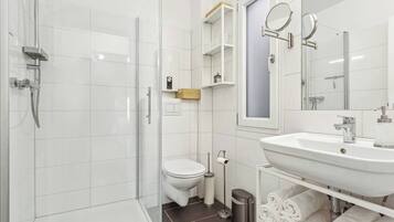 Een douche, handdoeken, zeep, toiletpapier