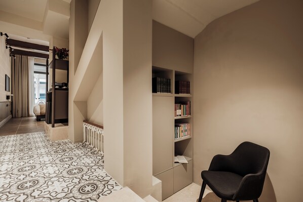 Un interior moderno con piso estampado, una silla negra y una estantería.