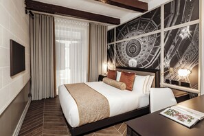Une chambre d’hôtel avec un grand lit, un bureau, une chaise, une télévision et un mur décoratif.
