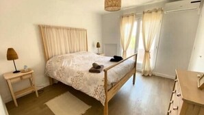 Ein Schlafzimmer mit einem Holzbett, einem Nachttisch, einer Lampe und einer Kommode.