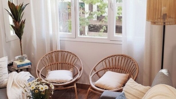 A cozy living room with a sofa, two wicker chairs, a small table with a vase of flowers, and a lamp. - Apartment "Apartamento la Marquesa" embraced by the walls of Cordoba.  (Córdoba)