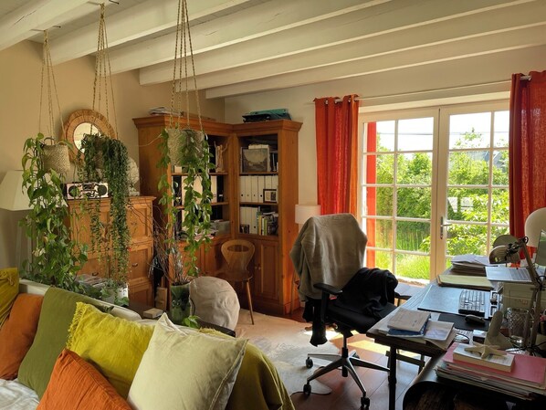 Un salon confortable avec un canapé, un meuble en bois et un bureau avec un ordinateur.