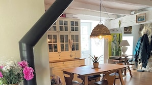 Un espacio habitable acogedor con estufa de leña, muebles de madera y zona de comedor.