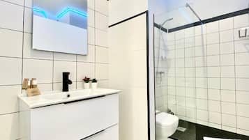 Een douche, handdoeken, zeep, shampoo