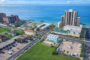 An aerial view of a coastal area with buildings, roads, and a beach. - 2 Levels - New Townhome -heated Pool - #1 (South Padre Island)