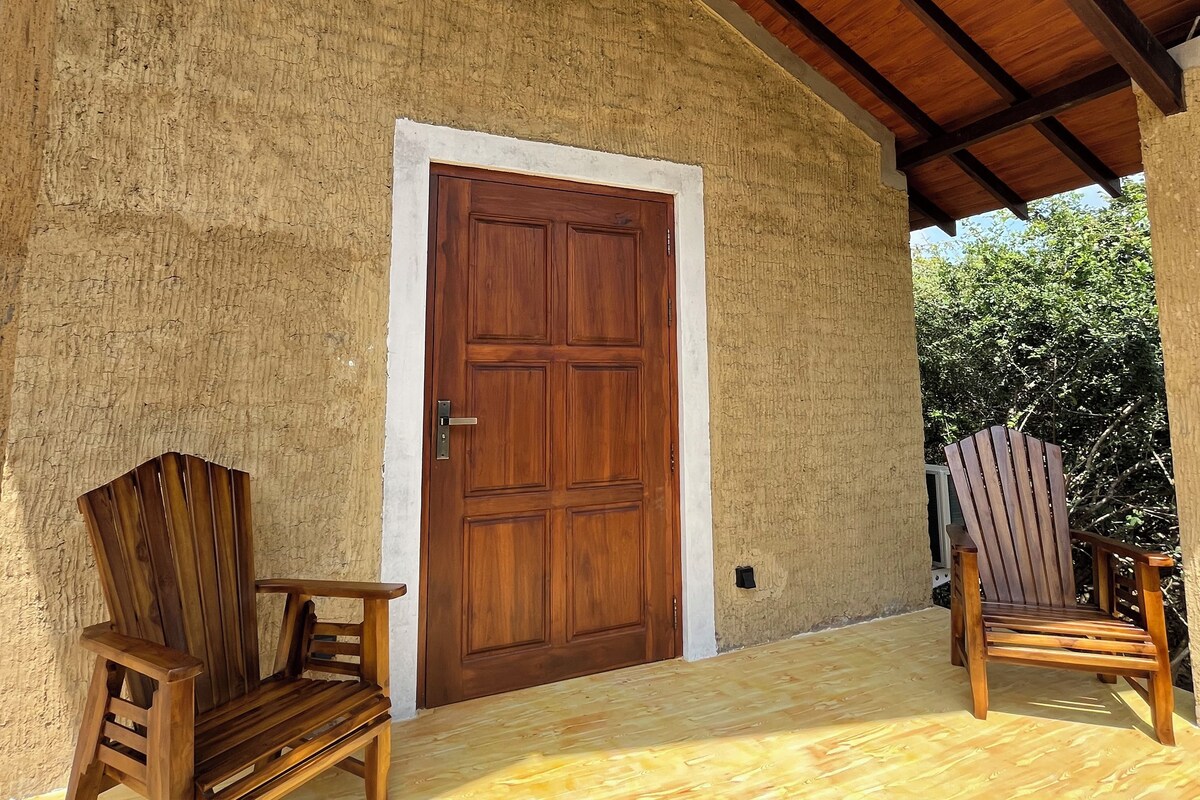 Une porte en bois avec un cadre blanc, deux chaises en bois et un plafond en bois.