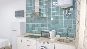 Cocina compacta con microondas, lavabo y lavadora.