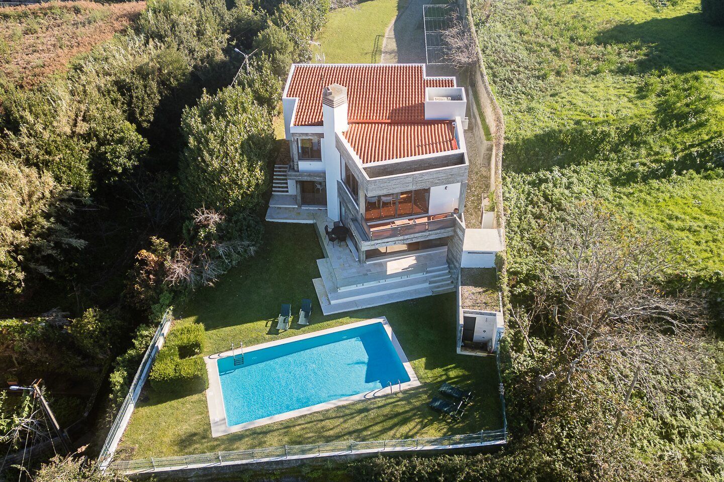 Una casa moderna de dos pisos con piscina y zona de patio.