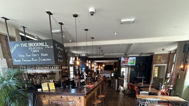 A cozy pub with a wooden floor, a bar area, and a private function room. - The Brookmill (London)