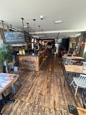 A cozy pub with a wooden floor, a bar area, and a private function room. - The Brookmill (London)
