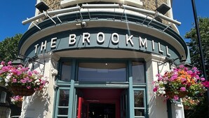 The entrance to The Brookmill with a red door and flower baskets. - The Brookmill (London)