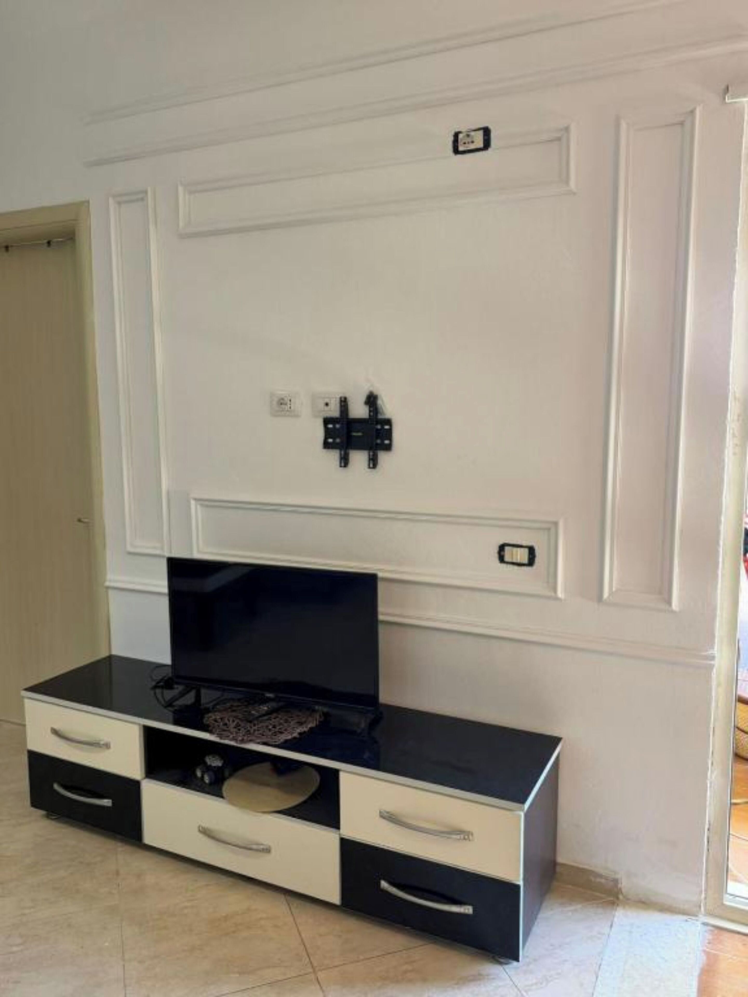 Une pièce équipée d’un meuble pour la télévision, d’un téléviseur à écran plat et d’une porte dotée d’une serrure.