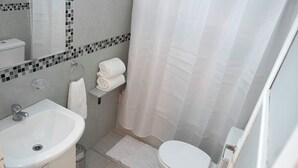 A bathroom with a white sink, toilet, and shower curtain. - MOT Nicaragua 5800 (Buenos Aires)