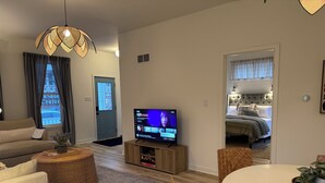 Ein modernes Wohnzimmer mit einer Couch, einem Fernseher und einem Essbereich.