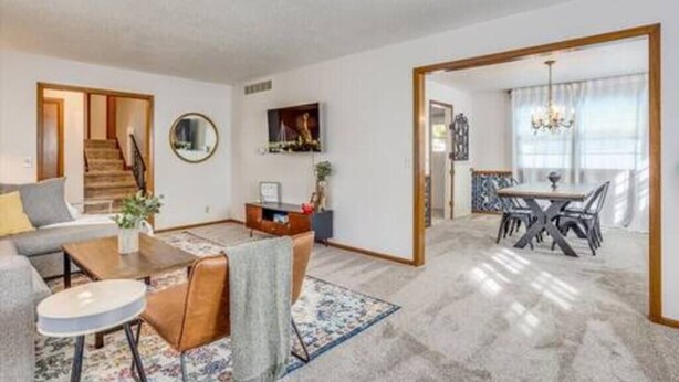 Una sala de estar moderna con un sofá, una mesa de centro y un comedor con mesa y sillas.