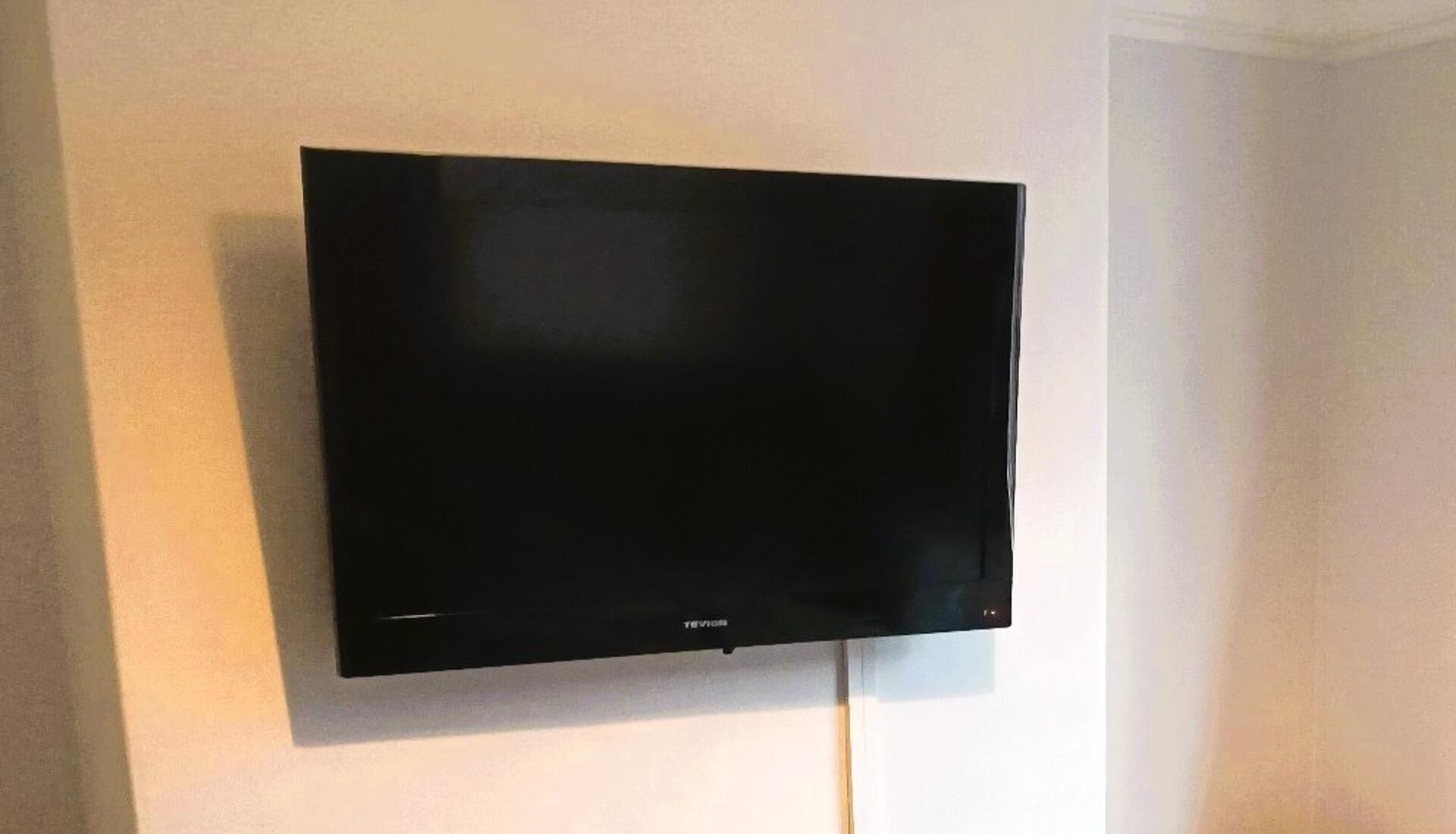 Ein Flachbildfernseher ist an einer weißen Wand montiert.