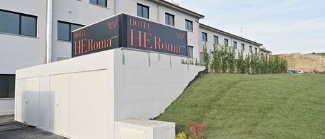 A modern hotel with a prominent sign reading "HOTEL HEROMA."