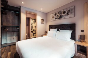 Relax in a spacious room with a large bed, bedside tables, and a sleek wardrobe.