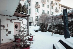 Stroll through the serene snow-covered courtyard, surrounded by potted plants and charming balconies.
