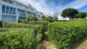 A modern building with multiple balconies and a well-maintained garden area. - Sol-y-Days la Santa Maria marinas view (Le Grau-du-Roi)