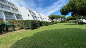 A modern building with a white facade, a well-maintained lawn, and a large tree. - Sol-y-Days la Santa Maria marinas view (Le Grau-du-Roi)
