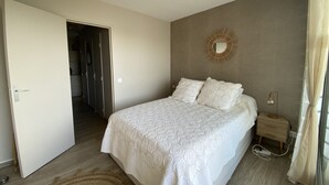 A bedroom with a bed, bedside table, and a mirror on the wall. - Sol-y-Days la Santa Maria marinas view (Le Grau-du-Roi)