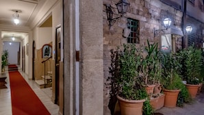 A hotel entrance with a red carpet, stone wall, and potted plants. - SKYLINE FLORENCE APARTMENT (Firenze)