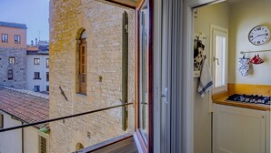 A narrow kitchen with a window overlooking a stone building. - SKYLINE FLORENCE APARTMENT (Firenze)
