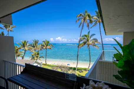 A balcony with a view of a beach and ocean.