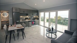 Una cocina moderna con comedor, ventanas amplias y un balcón.