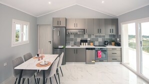 Una cocina moderna con gabinetes grises, una encimera blanca y un comedor con mesa y sillas.