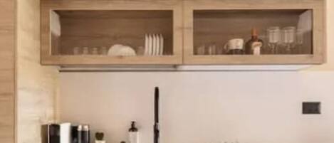 A modern kitchen with wooden cabinetry, a built-in dishwasher, and a countertop with various kitchen items.