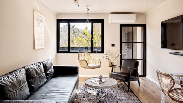 A modern living room with a leather sofa, a round coffee table, and two chairs. - Luxury Mamilla view - Three Bedroom Apartment, Sleeps 8 (Jerusalem)
