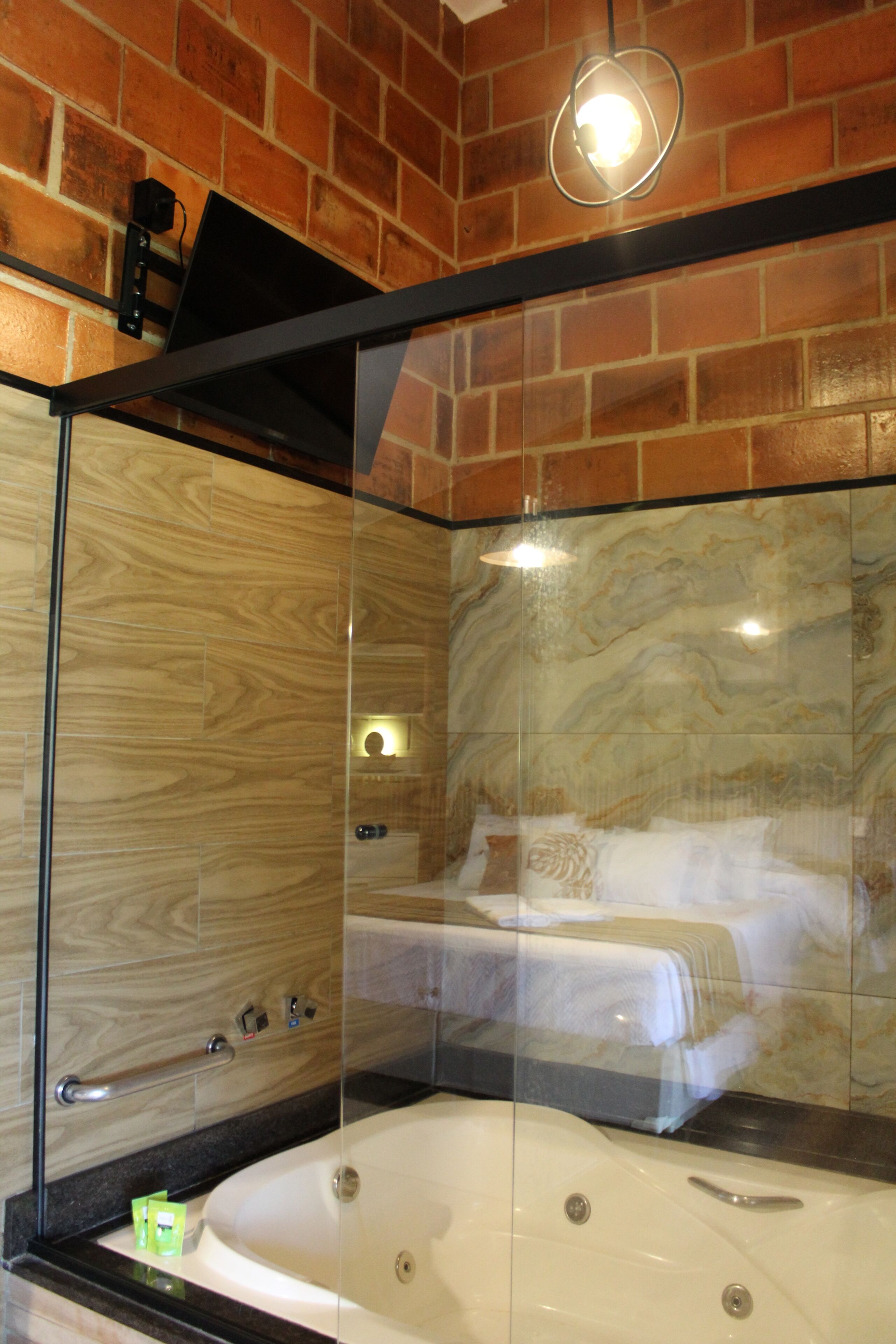 A modern bathroom with a glass-enclosed shower, a large bathtub, and a wooden wall design.