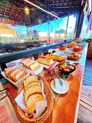 Ein reichhaltiges Buffet mit verschiedenen Brotsorten und Gebäck auf einem Holztisch.