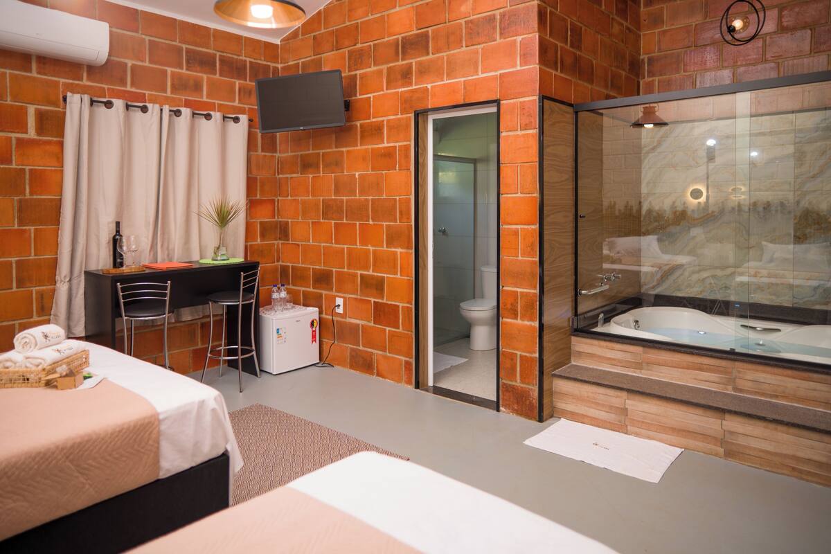 Ein Hotelzimmer mit Bett, Schreibtisch, Dusche und Badewanne.