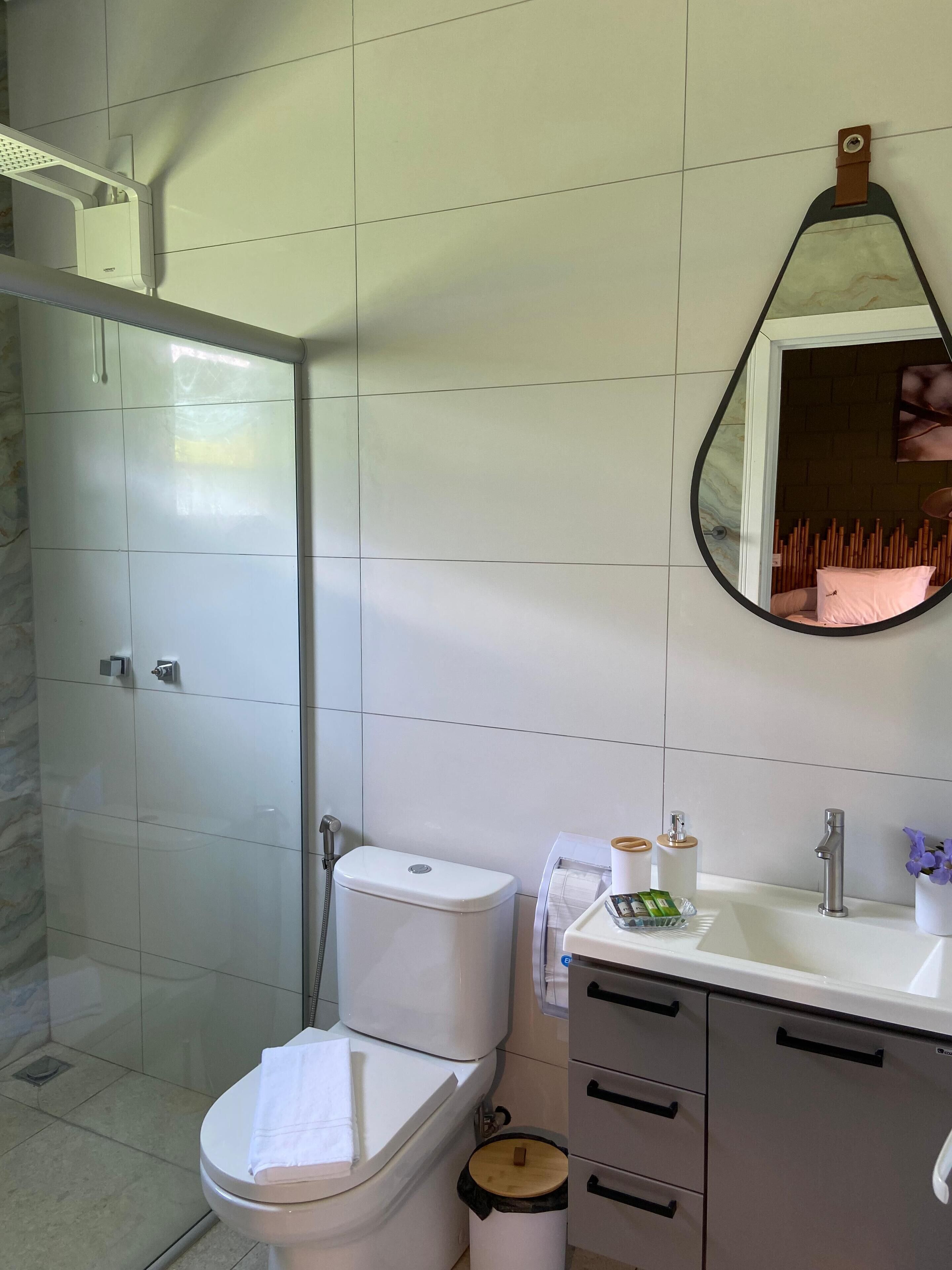 Un baño moderno con inodoro, lavamanos y ducha.