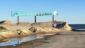 A beach sign with the text "Surfside Beach Gulf of Mexico". - Fishing Haven at Linda's Mermaid Cove (Freeport)