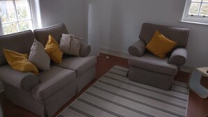 A living room with two sofas and a striped rug.