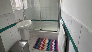 A bathroom with a shower, sink, and toilet.